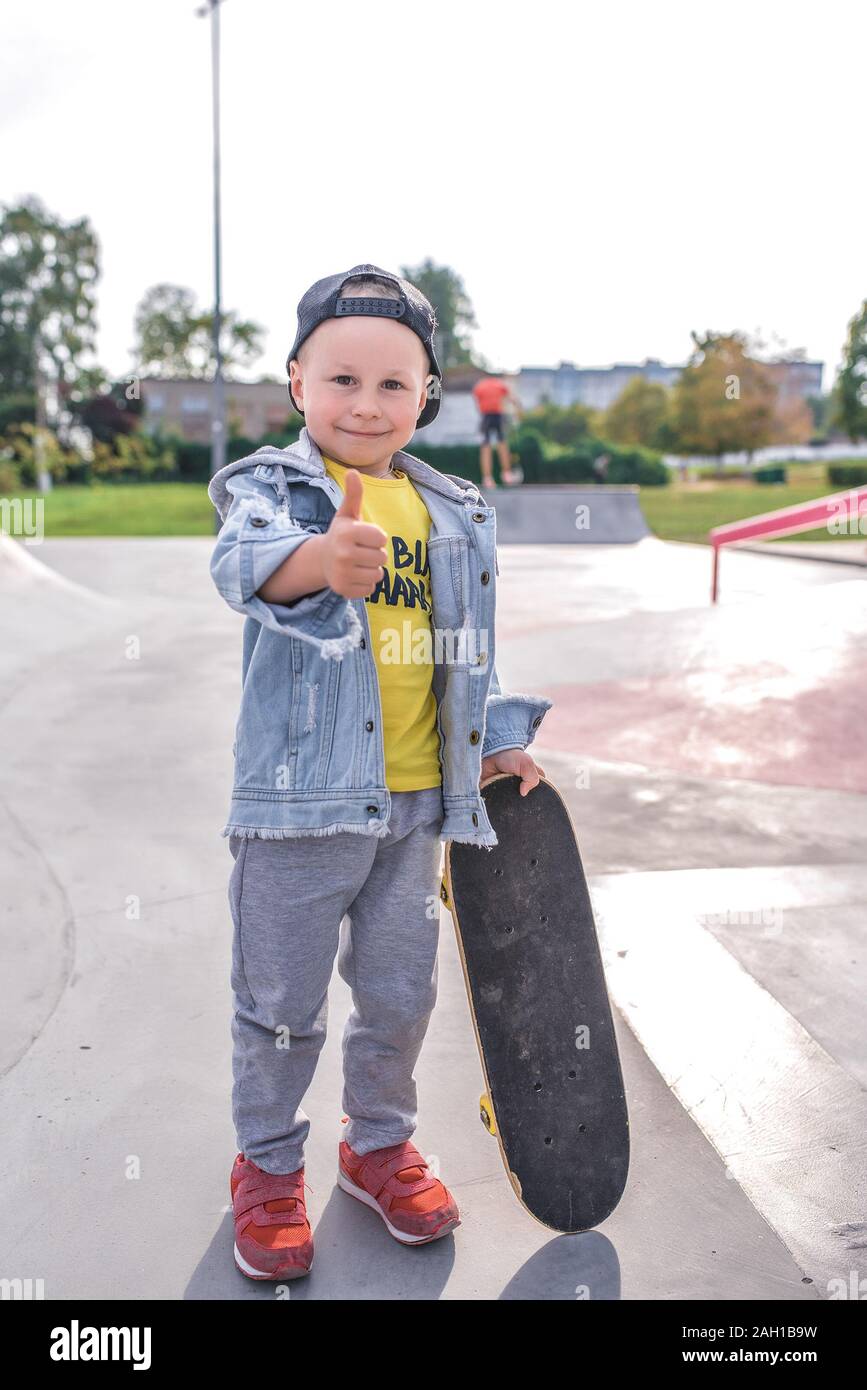 Niño 3-5 años de edad, el aprendizaje ride skateboard, día de otoño, casual  ropa de abrigo. Denim con gorra de béisbol. Driving Lessons, primera  experiencia Fotografía de stock - Alamy