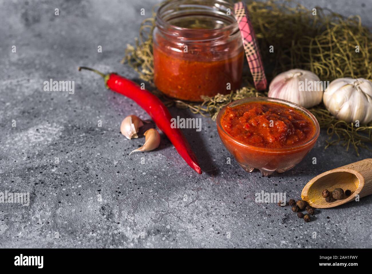 Mexicana tradicional, georgiano y árabe harissa pasta de pimiento sobre un fondo de cemento gris. Útil picante Foto de stock