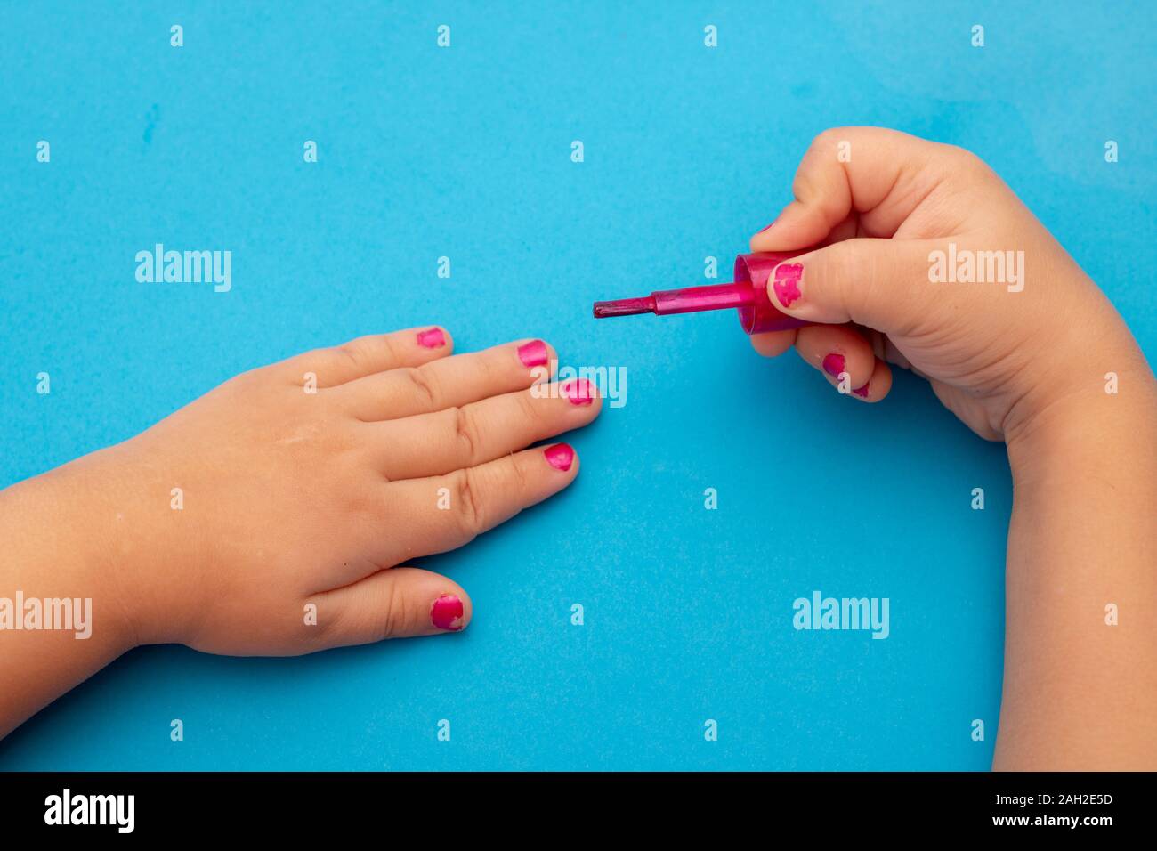 Children's manicura. Las manos de los niños, pintar sus uñas con esmalte de  uñas de color. Rojo de Manicura Uñas infantiles Fotografía de stock - Alamy