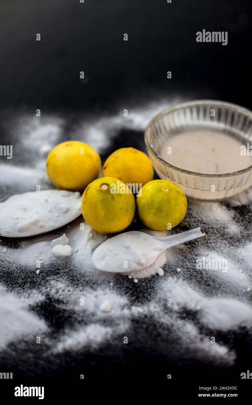 Mascarilla de bicarbonato de sodio en un recipiente de cristal sobre  superficie de madera junto con bicarbonato espolvoreado sobre la superficie  y limones y también en la superficie. Utilizado para blemi Fotografía