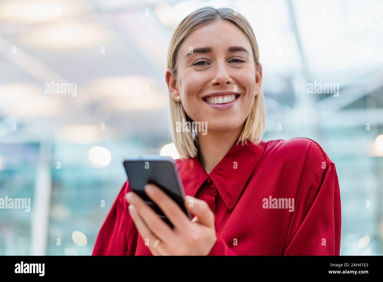 Retrato de una sonriente joven empresaria con teléfono celular Foto de stock