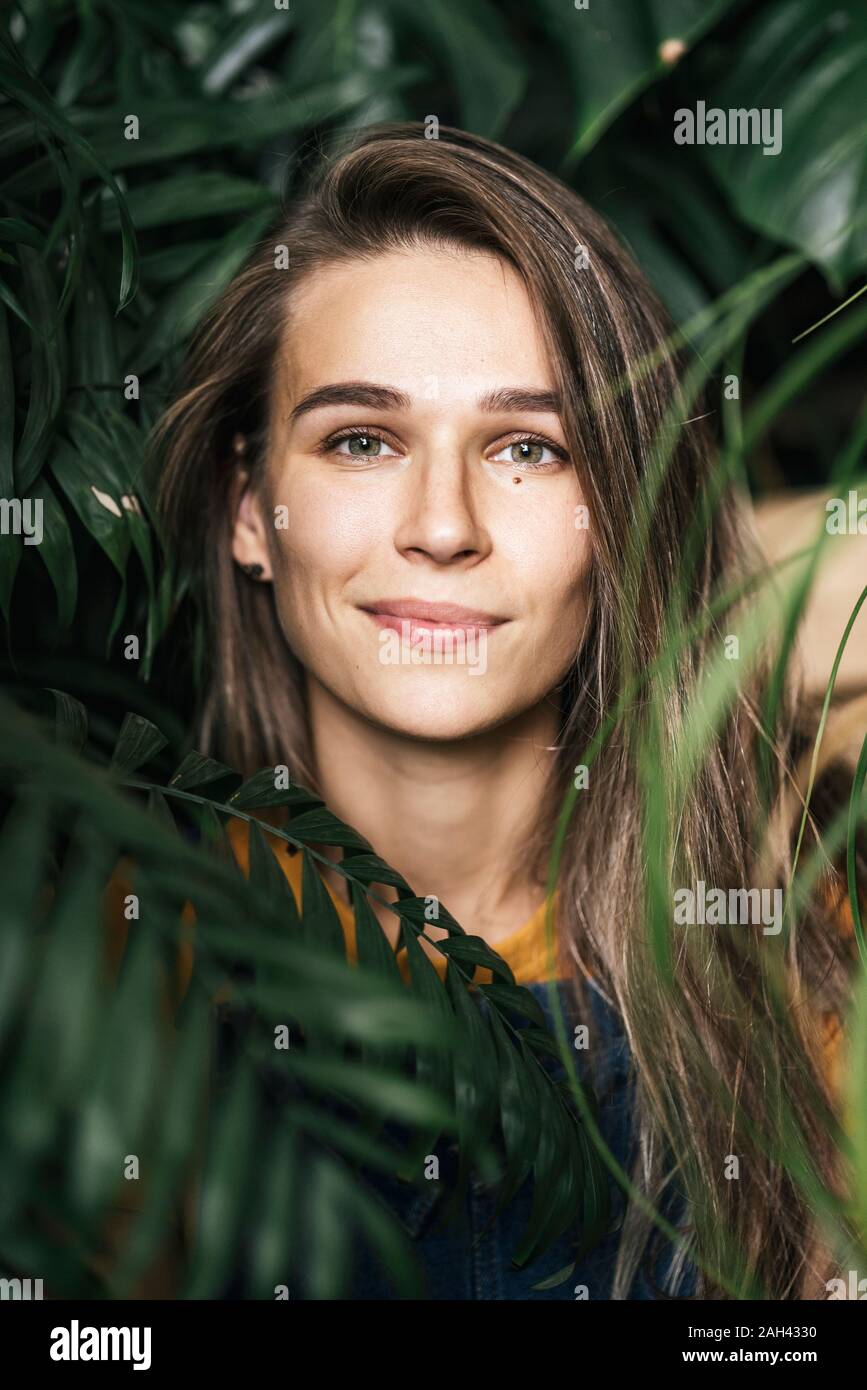 Retrato de una joven en medio de plantas verdes. Foto de stock