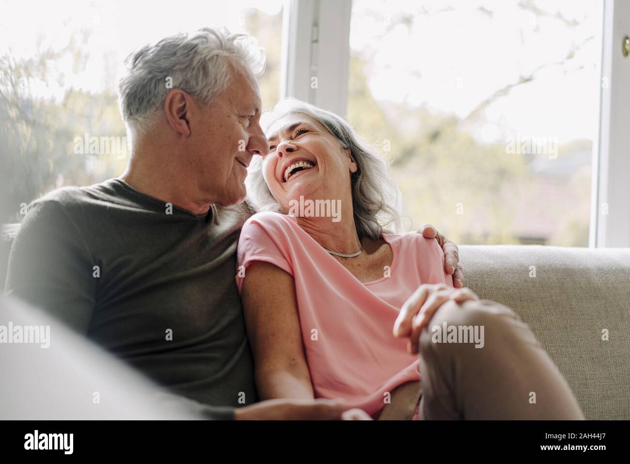 Feliz pareja senior relajándose en sofá en casa Foto de stock