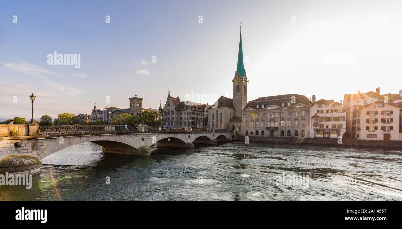 Suiza, en el cantón de Zurich, Zurich, Munsterbrucke puente al atardecer con la iglesia Fraumunster en segundo plano. Foto de stock