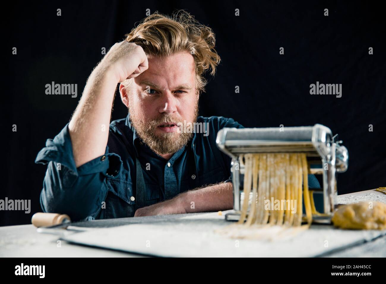 Cocinero haciendo Hobby tagliatelle frescos con máquina de pasta Foto de stock