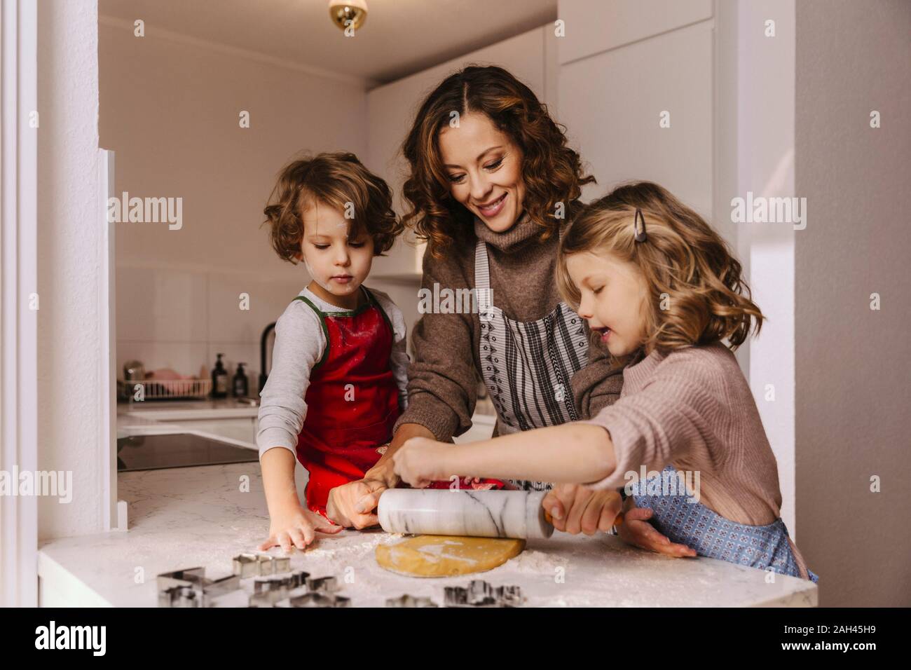 Madre y dos hijas preparar galletas de Navidad en la cocina Foto de stock