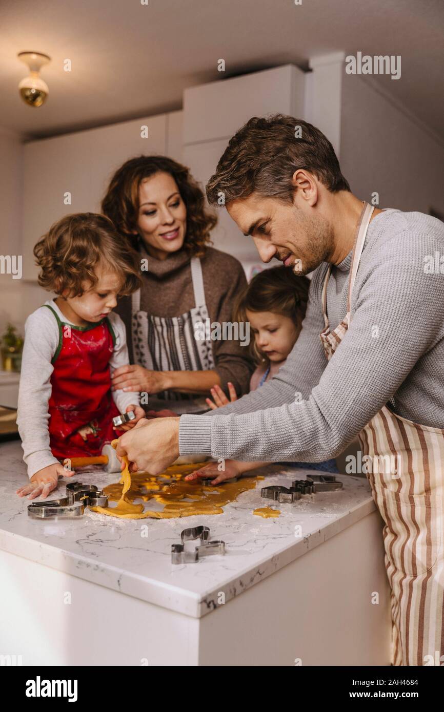 Familia preparar galletas de Navidad en la cocina Foto de stock
