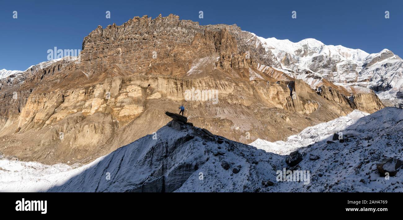 Montañero en la cima de una roca, Dhaulagiri Circuito Trek, Himalaya, Nepal Foto de stock