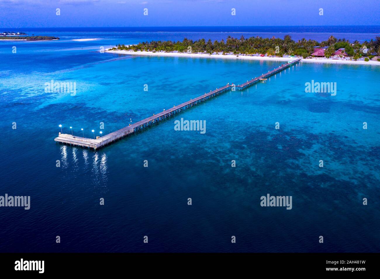 Maldivas, Bodufinolhu, vista aérea del muelle del centro turístico costero de South Male Atoll al atardecer Foto de stock
