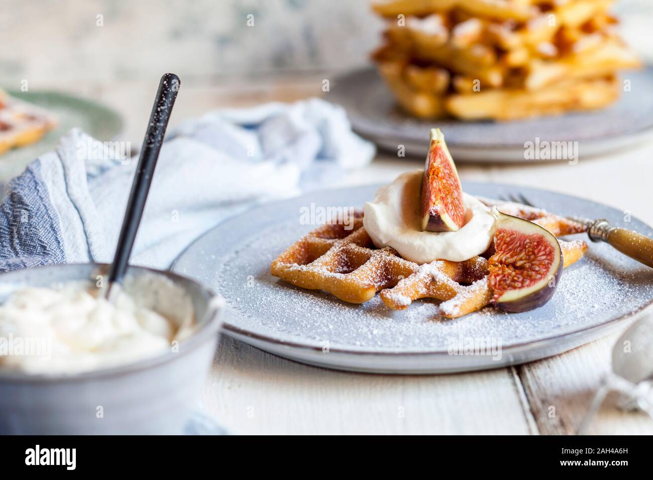 Espesor gofre belga con crema batida, azúcar en polvo y las figs. Foto de stock