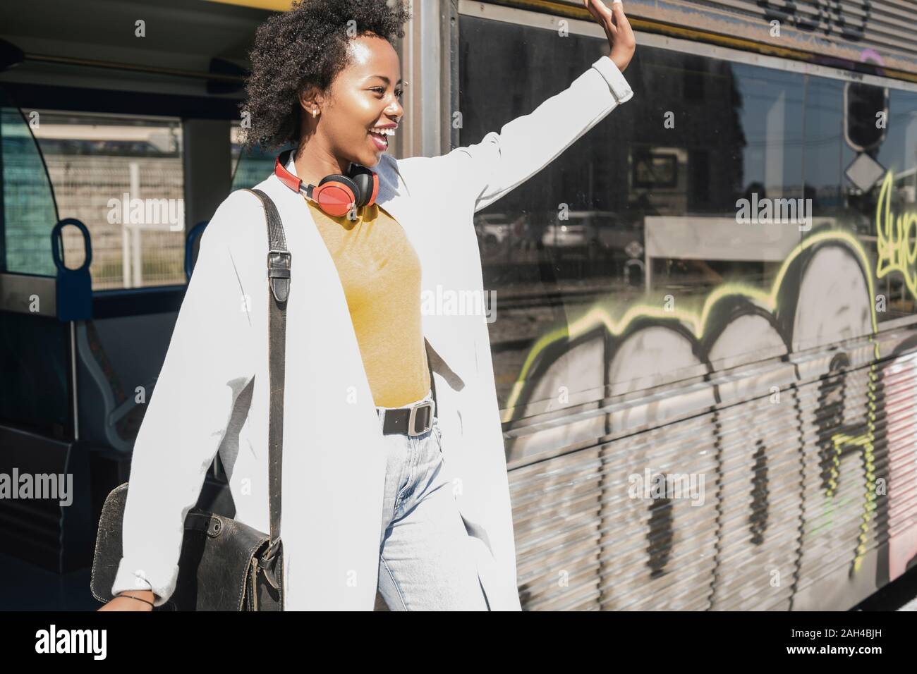 Feliz joven bajarse un tren Foto de stock