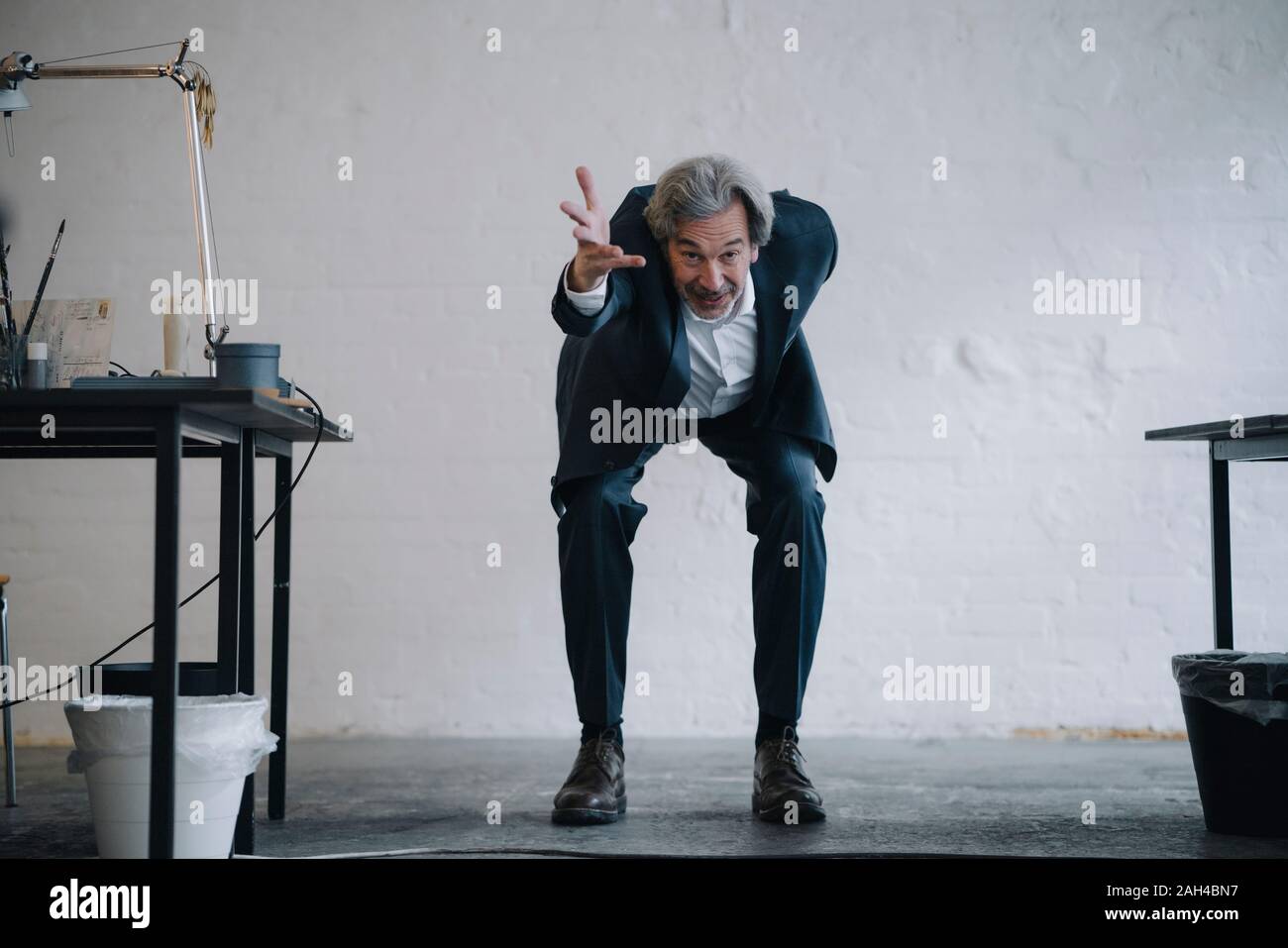 Empresario Senior haciendo gimnasia en la oficina Foto de stock