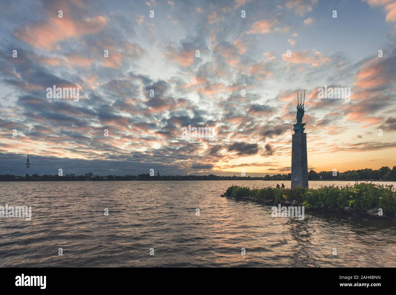 Alemania, Hamburg Alster, el lago con la escultura de tres hombres en el barco por Edwin Paul Scharff al atardecer Foto de stock