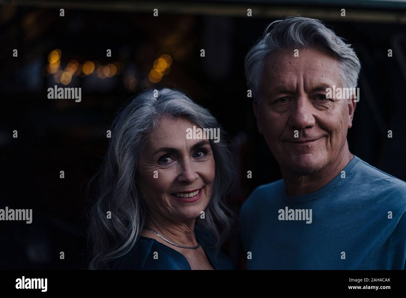 Retrato de una sonriente pareja senior exteriores por la noche Foto de stock