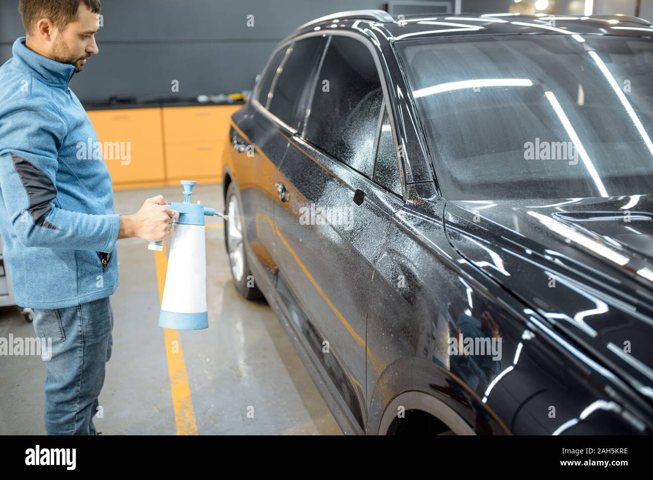 Servicio de coche trabajador extrayendo agua de la carrocería del