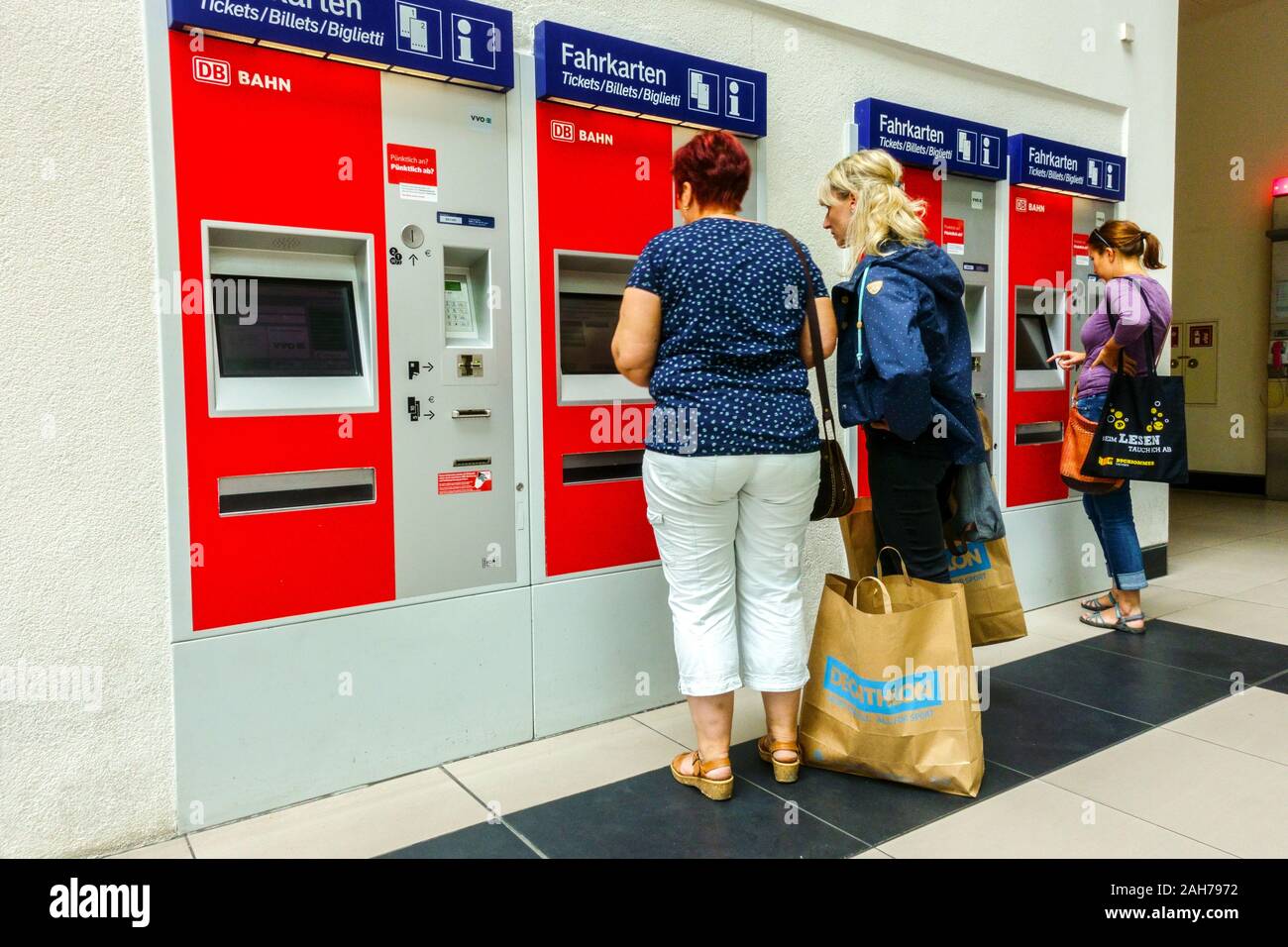 Las mujeres alemanas con bolsas de compras comprar billetes en las máquinas de billetes de auto-servicio, DB, Deutsche Bahn estación Dresden Alemania Foto de stock