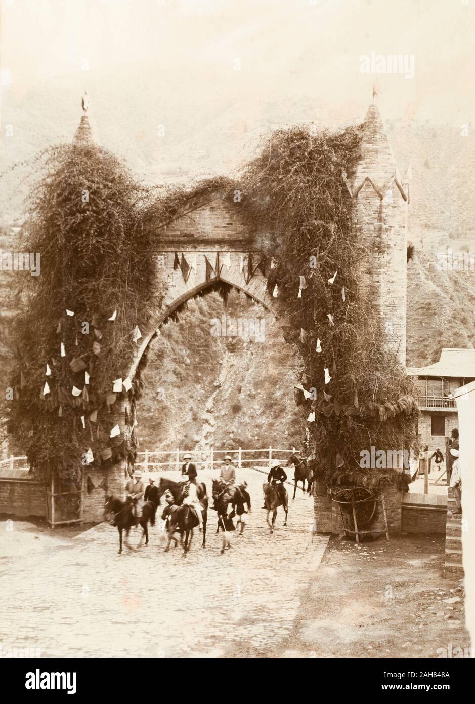 La India, cuatro funcionarios del gobierno británico, acompañado por una escolta de guardias indios, paseo a caballo a través de un arco de piedra decorada a su llegada en la chamba para la instalación de la raja. Título original: Llegada en Chamba, 1920. 2001/243/1/1/3/83. Foto de stock