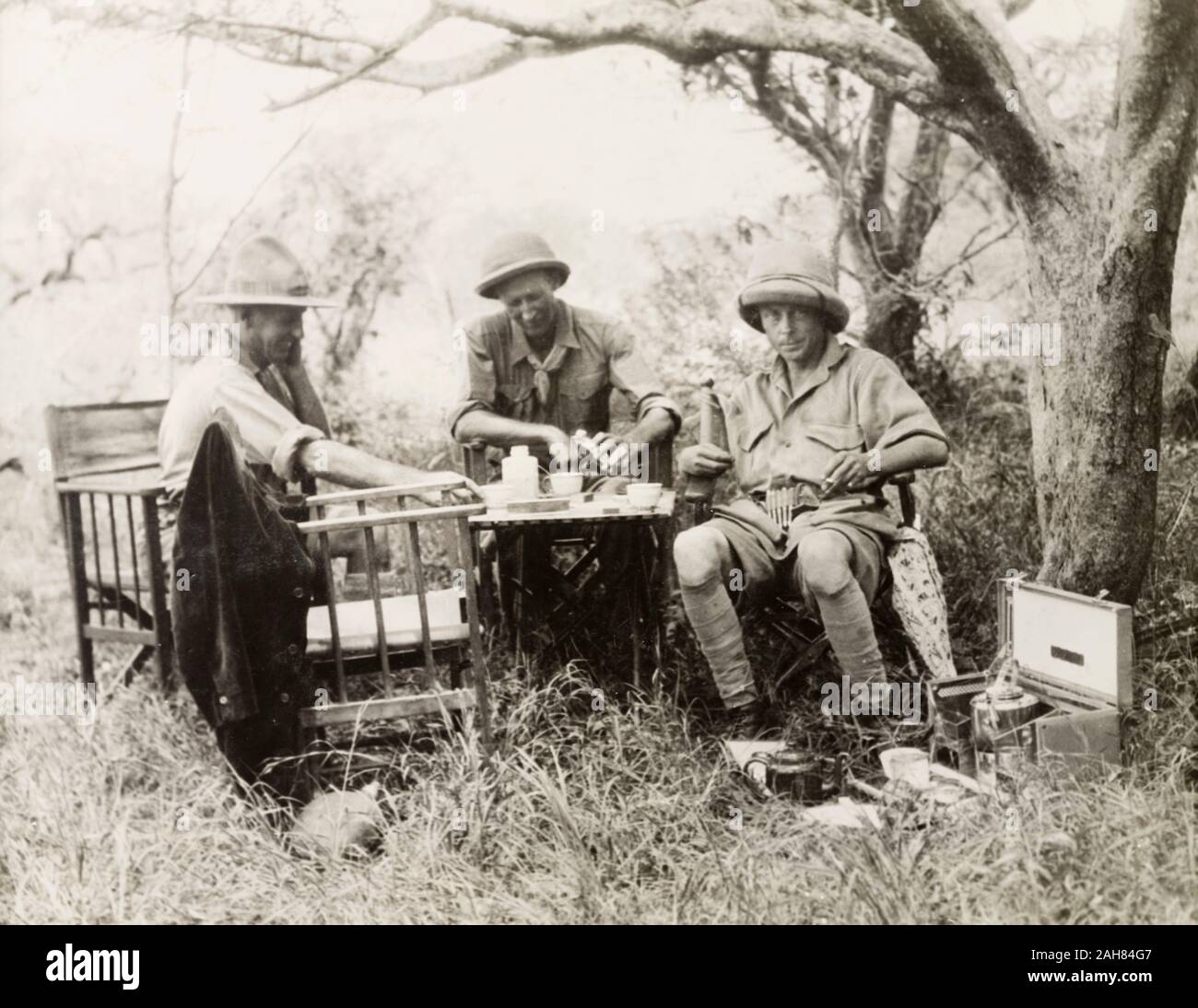 TanzaniaTanganyika Edward, Príncipe de Gales (derecha), más tarde el Rey Eduardo VIII, se sienta en una mesa debajo de un árbol, beber té con dos compañeros, mientras que en safari en Tanganica. Esta imagen se cree que ha sido eliminado de la Blixen album.EH manuscrito título: Edward Prince of Wales (derecha) de safari en Tanganica (Tanzania) en 1927. Denys Finch Hatton, asistente del centro "cazador blanco", de 1927. 1995/076/1/2/2/33. Foto de stock