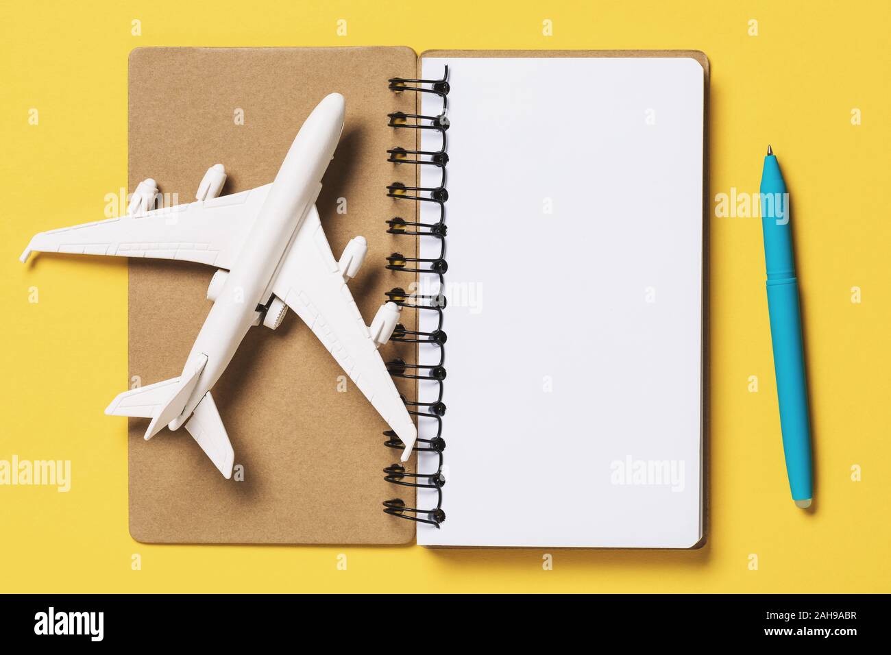 Avión de juguete con una notebook sobre un fondo amarillo, vista superior.  Concepto de planificación de vuelo Fotografía de stock - Alamy