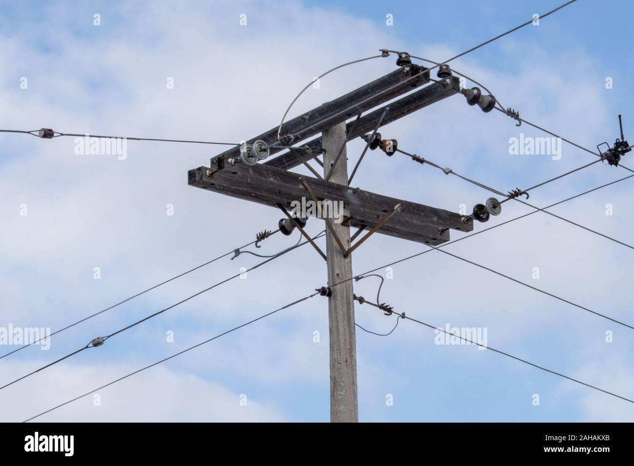 Un rural cruce de cables eléctricos es elevada por un palo de madera. Las  conexiones de las líneas de poder transmitir electricidad en todas  direcciones, llevando la Fotografía de stock - Alamy