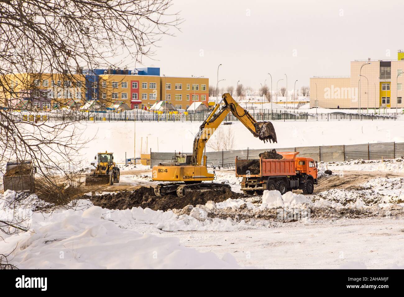 En invierno, el terraplén se lleva a cabo en el sitio de construcción, suelo congelado se retira cuando cavar un hoyo Foto de stock
