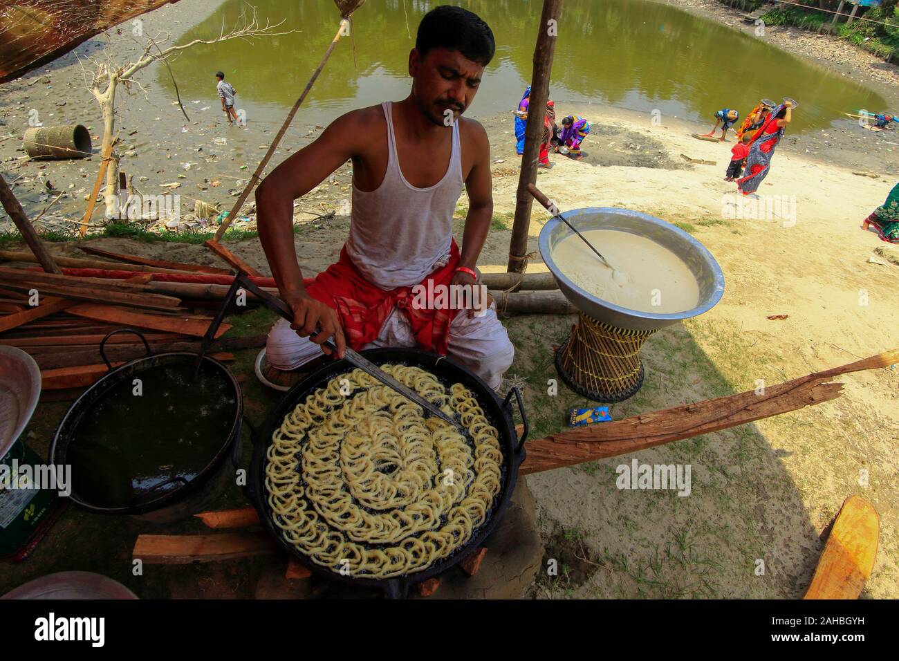 Un hombre hace dulces tradicionales en su stand en una feria Boishakhi Mela, con ocasión del Año Nuevo Bengalí. Narayanganj, Bangladesh Foto de stock