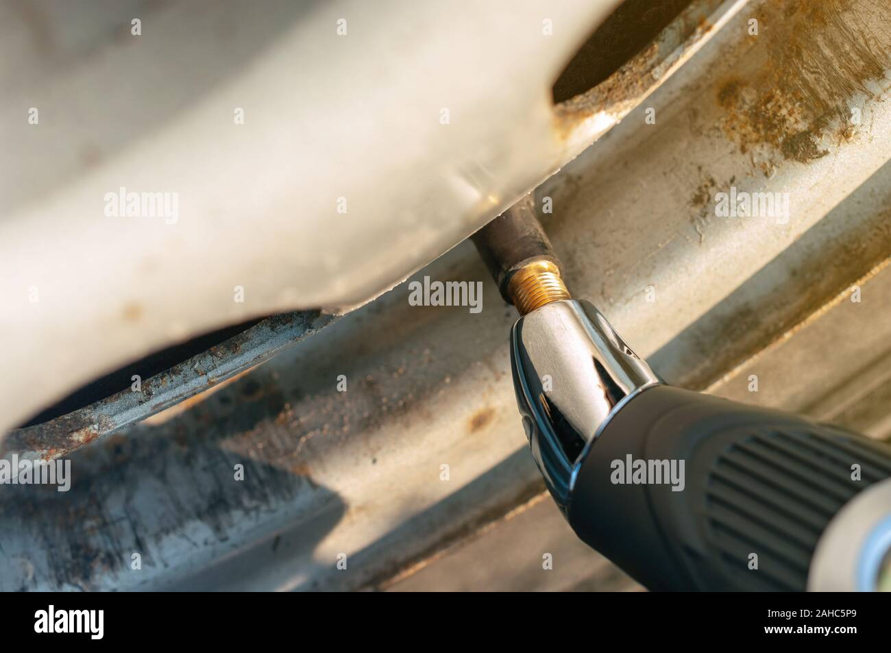 Comprobación de la presión de los neumáticos con manómetro Foto de stock