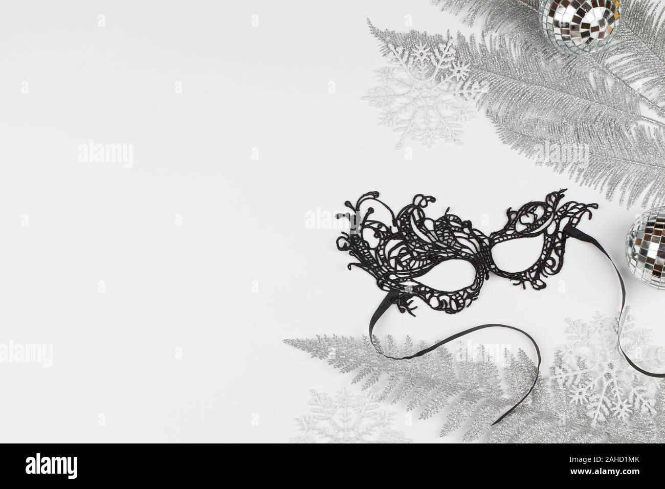 Bello carnaval antifaz negro, copos de nieve, las ramas de los árboles y la  decoración de Navidad sobre fondo de color . Concepto de Navidad. Vista  superior plana cerca laicos Fotografía de