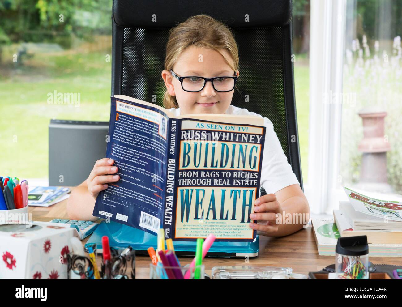 Chica leyendo la riqueza del libro motivacional Foto de stock