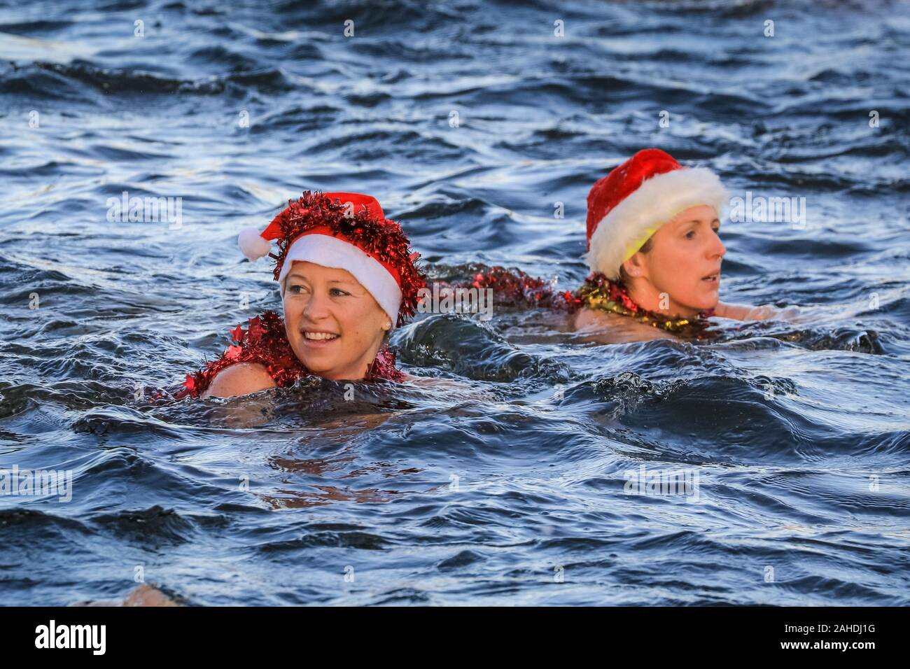 El día de Navidad nadadores en Santa hat nadar en aguas abiertas en frío en la carrera de natación para la Copa 'Peter Pan', el Club Natación serpentina, Hyde Park, Londres Foto de stock
