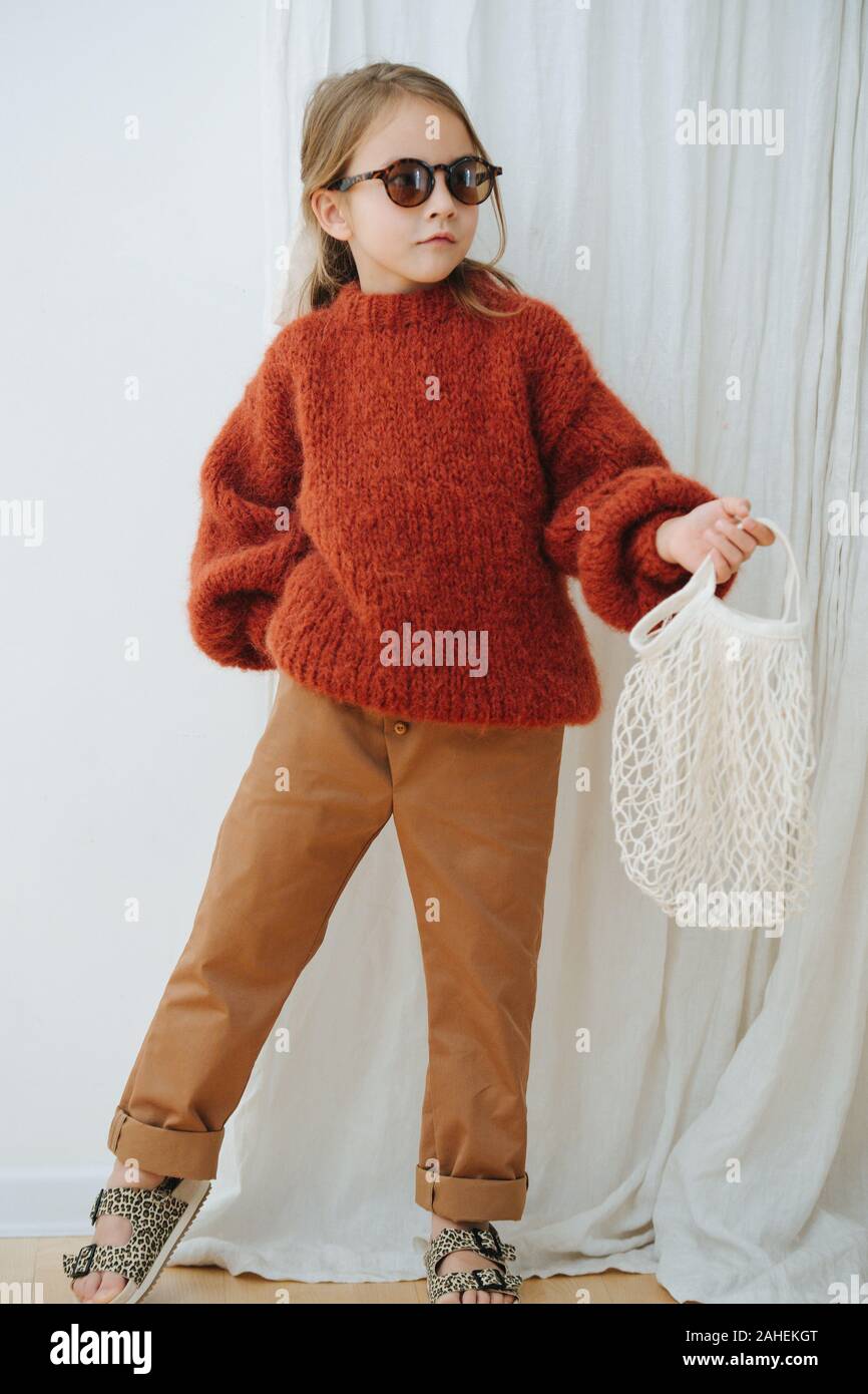 Niña de moda en naranja oscuro suéter tejido con malla Fotografía de stock  - Alamy