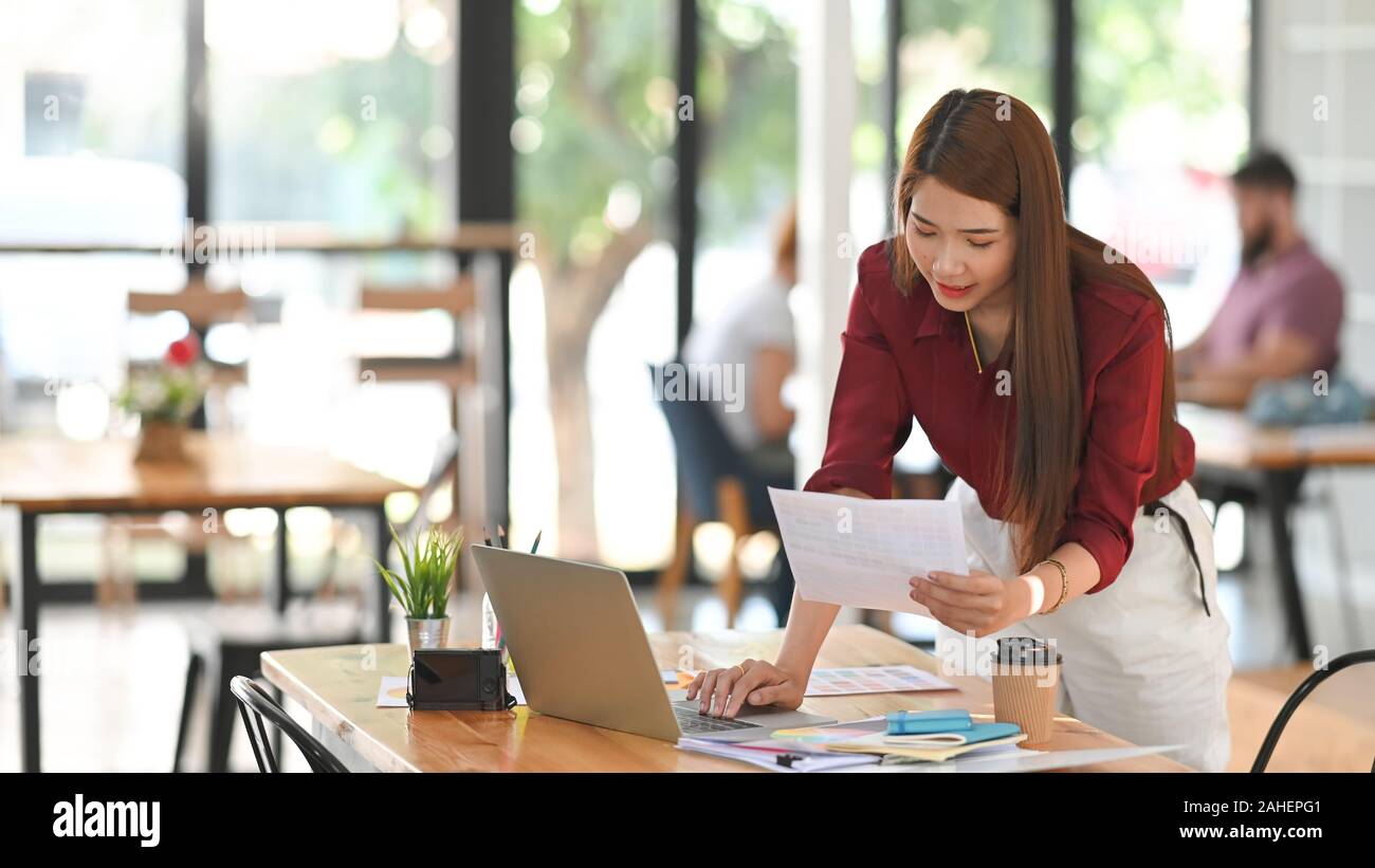 Mujer joven creativo Guía de color seleccionada con el portátil sobre el espacio de trabajo del artista. Foto de stock
