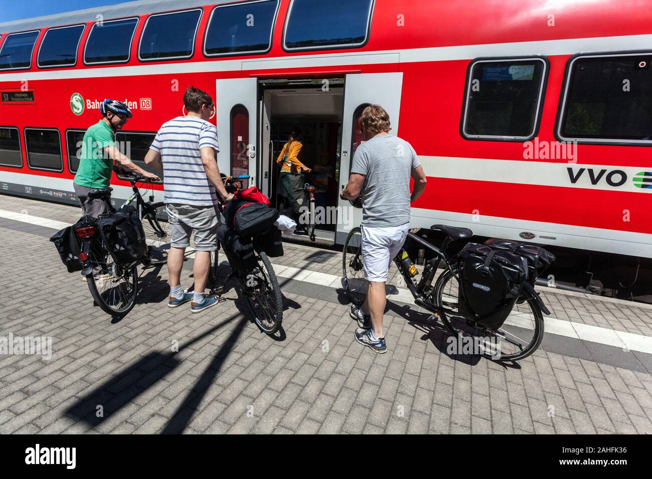 Alemania viaje en bicicleta por tren, el grupo de gente en el andén ferroviario acaba de llegar en tren regional Deutsche Bahn Sajonia Foto de stock