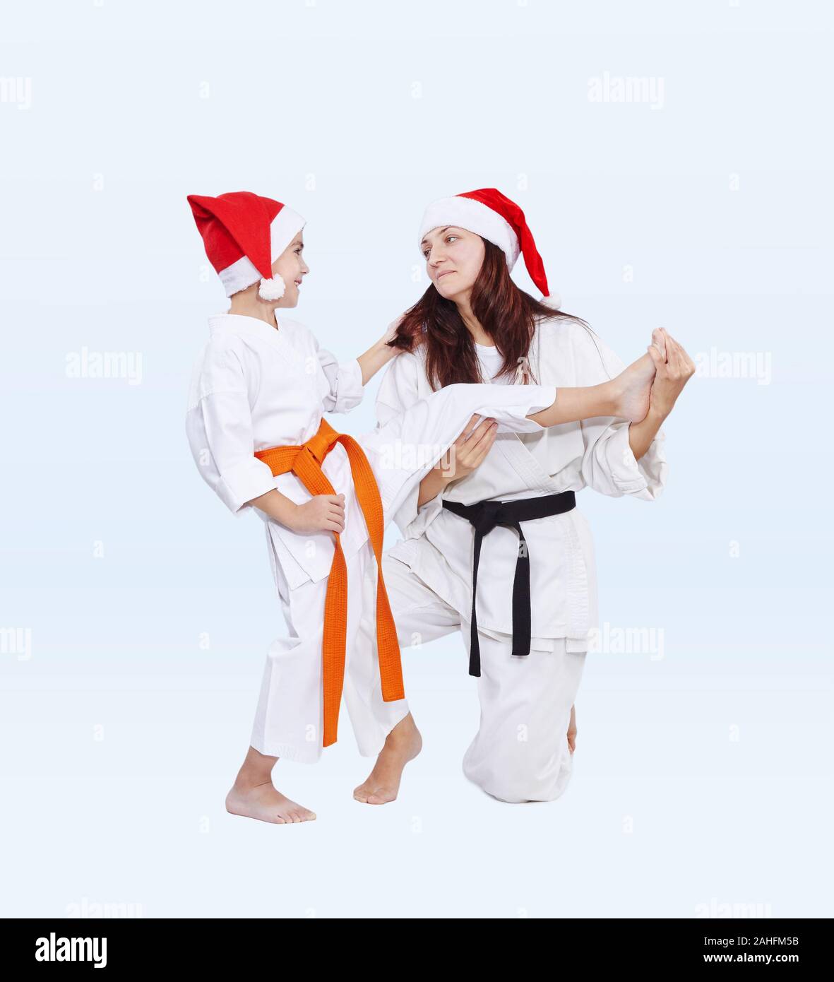 Con cinturón negro y naranja en las tapas de Santa Claus deporte son la formación de la familia Patada pierna Foto de stock
