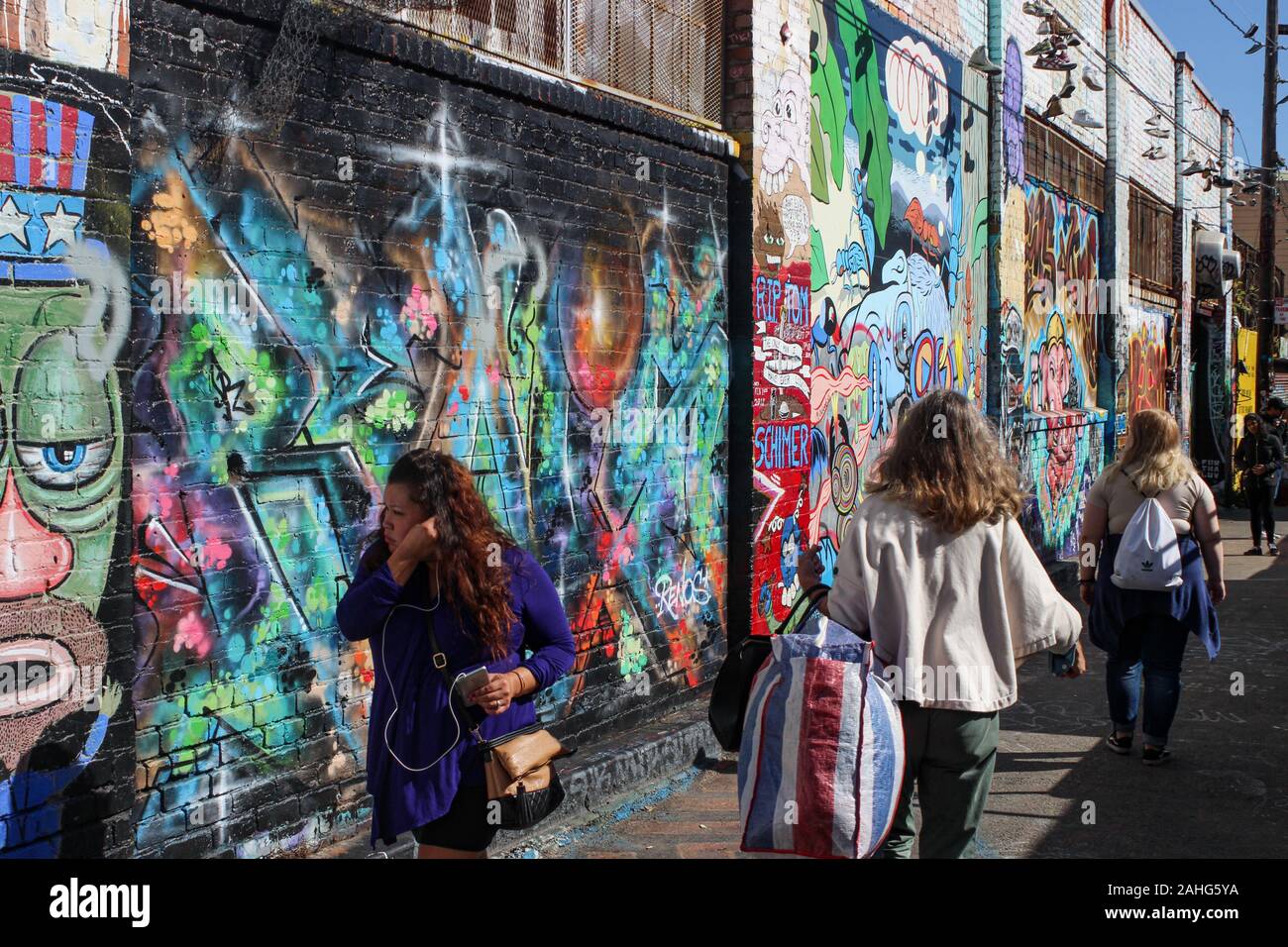 La gente pasea por el Clarion Alley con famosas pinturas murales en las paredes de la Misión en San Francisco, Estados Unidos de América Foto de stock