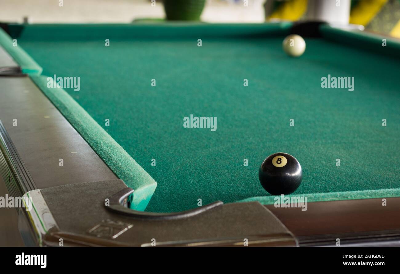 Bola blanca y la bola negra en lados opuestos de una mesa de billar con  tapete verde. Concepto de juego de recreo Fotografía de stock - Alamy