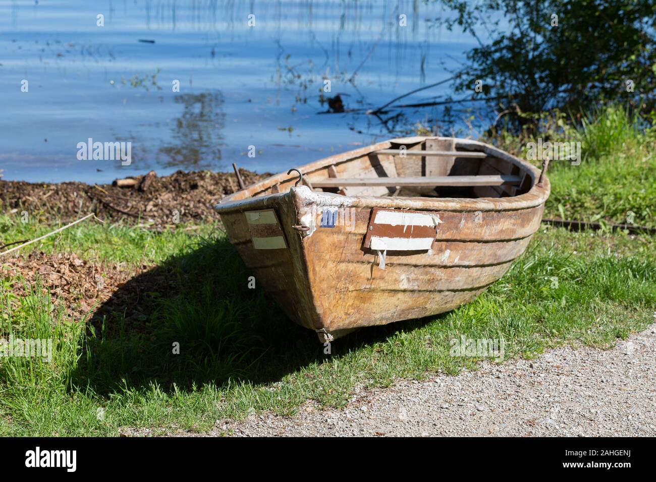 Fila de madera bote / bote de remos en la orilla del lago Ammersee. Pintoresca y bella escena, tranquila y pacífica. Foto de stock