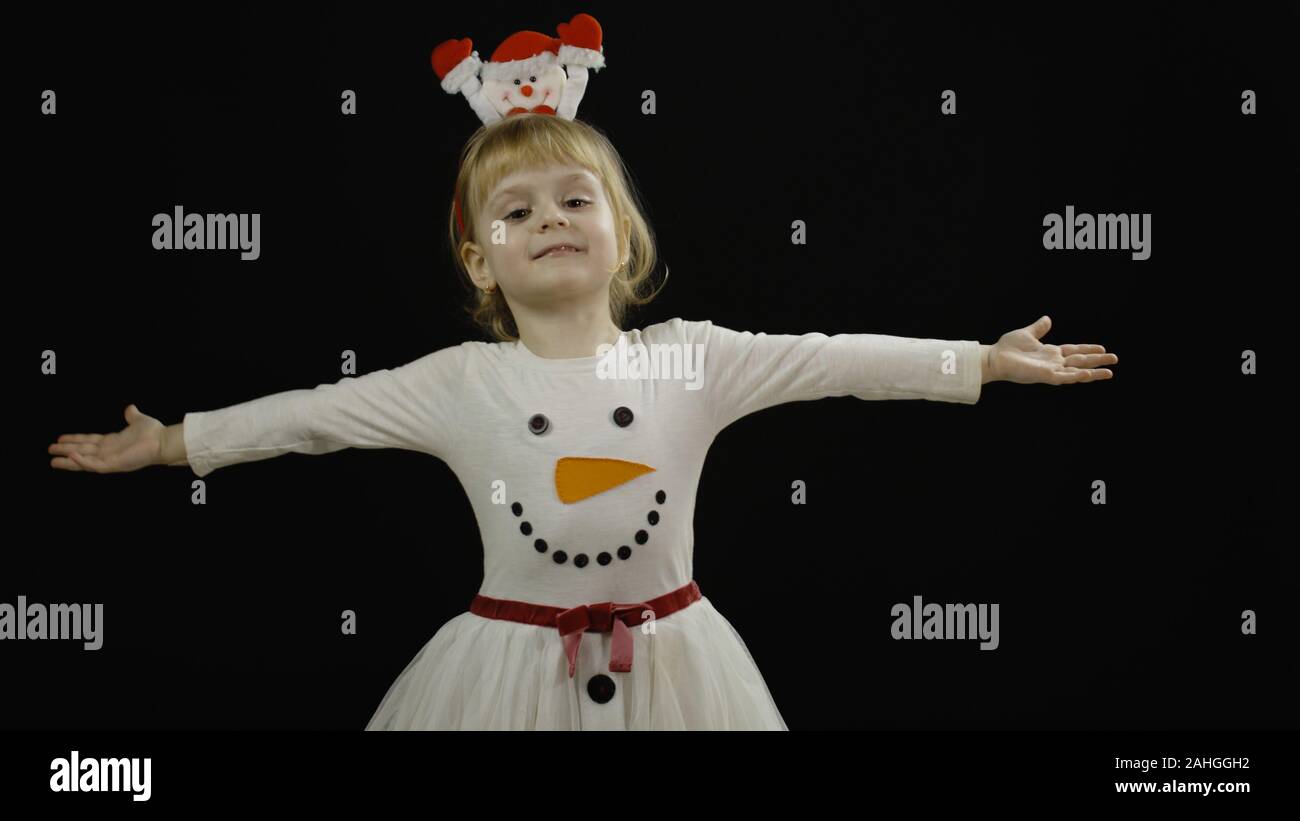 Feliz hermosa hijita en el muñeco de nieve disfraz. Concepto de Navidad.  Positiva, bonita, de cuatro años de edad, hacer caras y sonrisa. Fondo  negro Fotografía de stock - Alamy