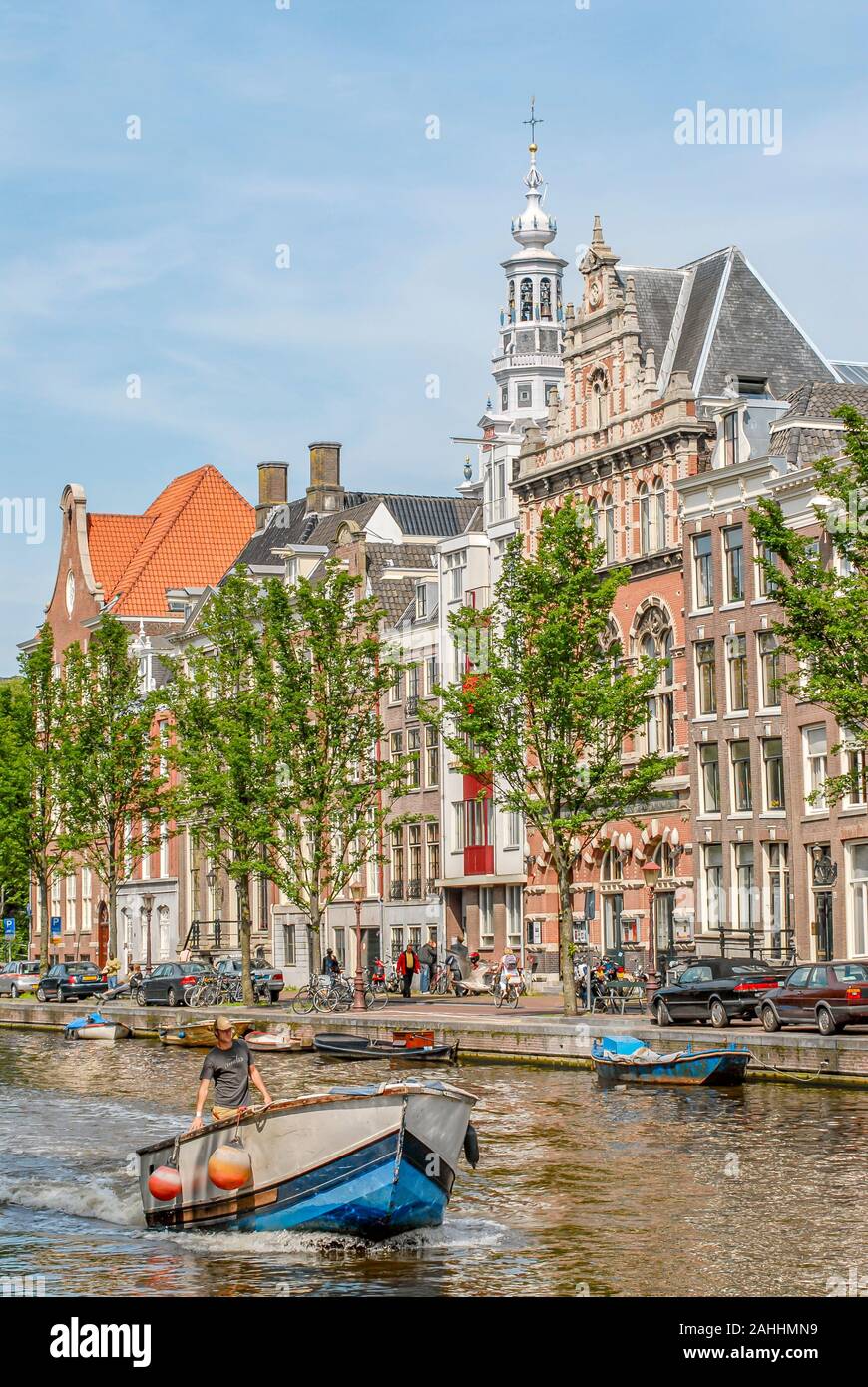 Pequeñas embarcaciones que se ejecutan a través de un canal de agua, Netherlande Amsterdam Foto de stock