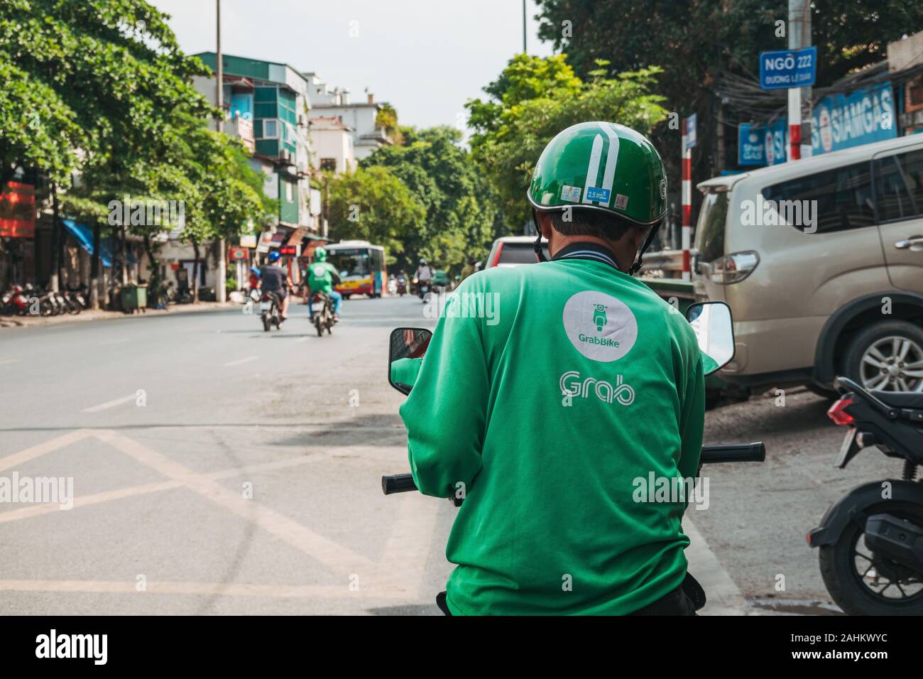Un Grab ciclista verifica su telefono esperando el siguiente trabajo en Hanoi, Vietnam. Grab es más popular del Sudeste de Asia paseo saludando y entrega app Foto de stock