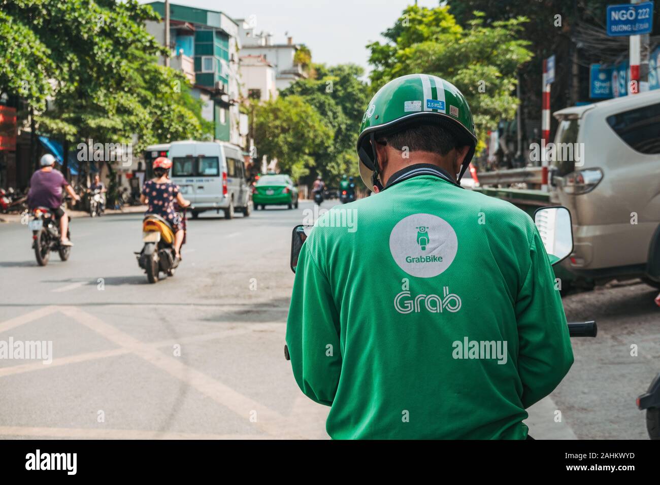 Un Grab ciclista verifica su telefono esperando el siguiente trabajo en Hanoi, Vietnam. Grab es más popular del Sudeste de Asia paseo saludando y entrega app Foto de stock