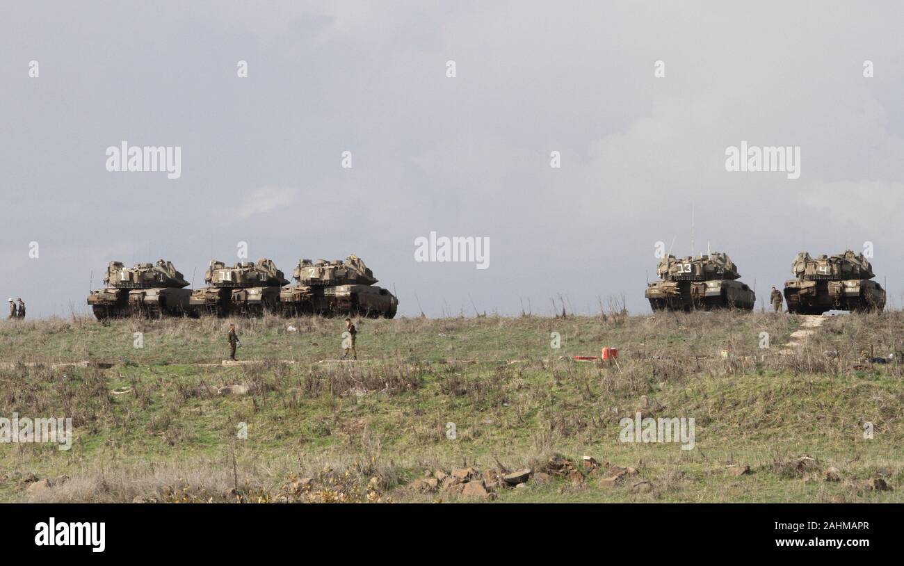 Las Alturas del Golán. 30 dic, 2019. Soldados israelíes y tanques militares se ven en las Alturas del Golán ocupadas por Israel durante un taladro militar el 30 de diciembre, 2019. El ejército israelí se encontraba en estado de máxima alerta en las Alturas del Golán, en preparación para posibles represalias por parte de EE.UU. Irán tras las huelgas en Kata'ib Hezbollah instalaciones en Iraq y Siria el domingo. Crédito: Gil Cohen Magen/Xinhua/Alamy Live News Foto de stock