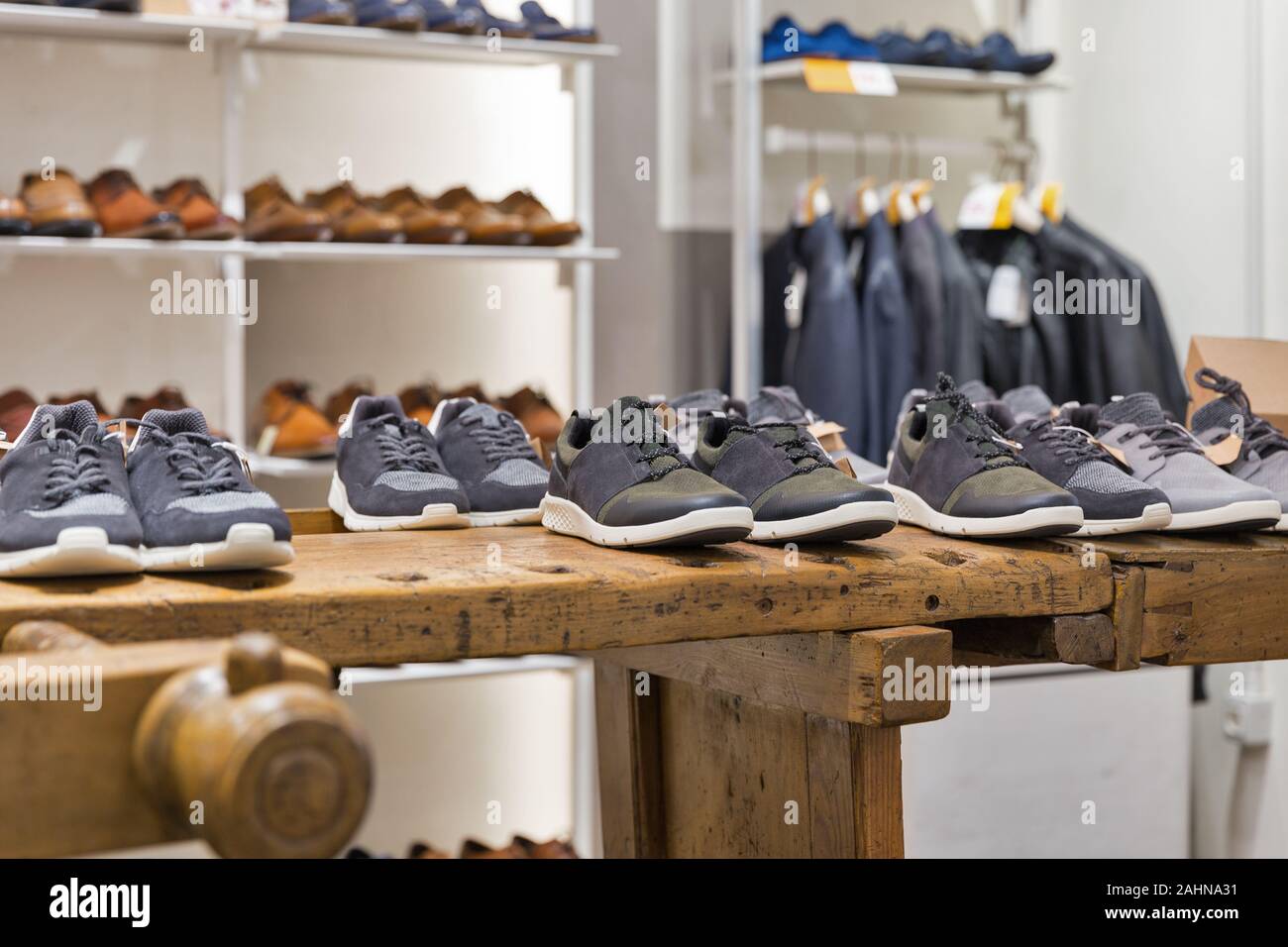 Visualización de zapatos en estantes de madera en la moderna tienda de ropa para  hombres Fotografía de stock - Alamy