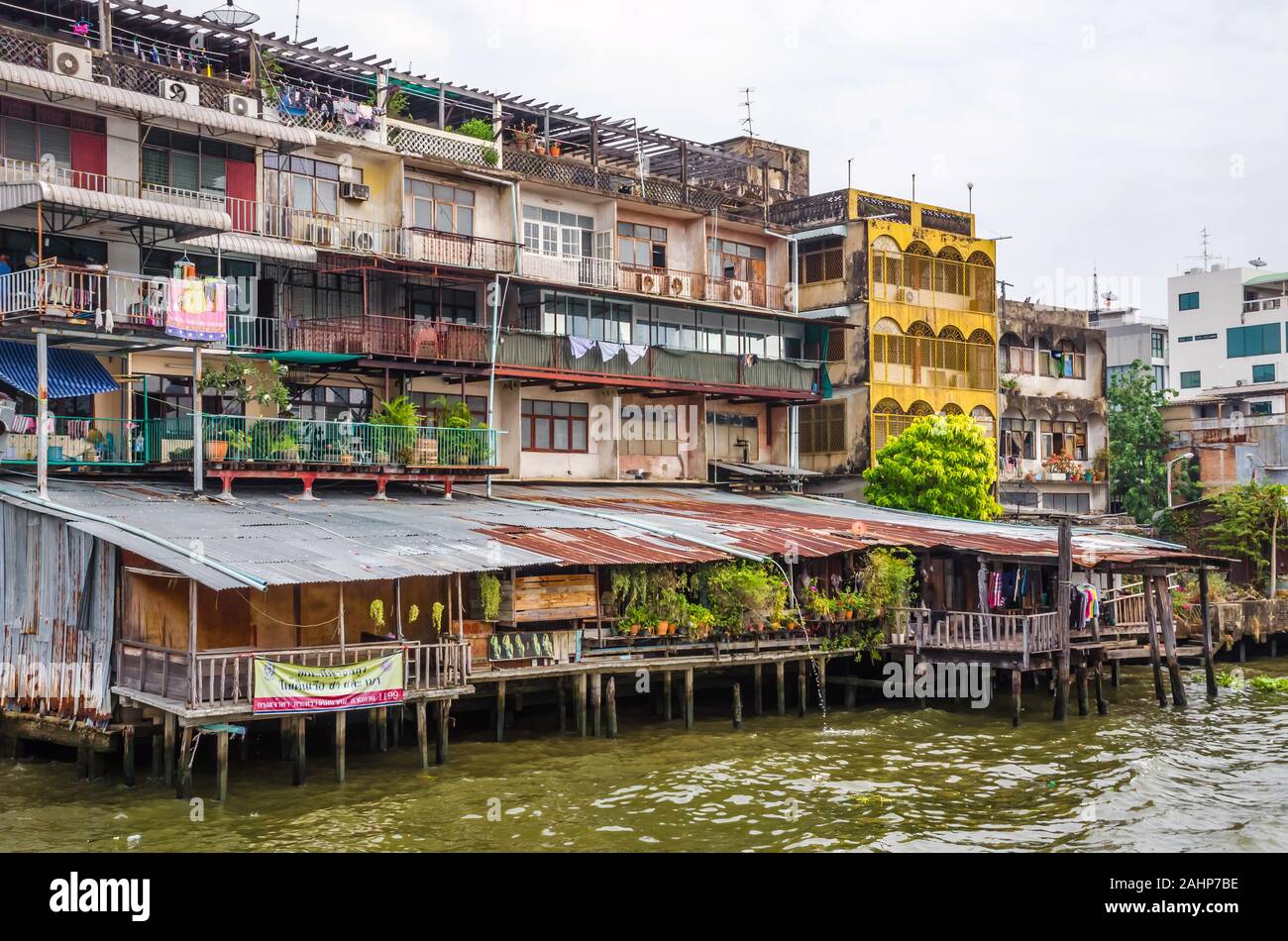 BANGKOK, TAILANDIA - Diciembre 23, 2018: los viejos barrios de madera para los pobres desfavorecidos sobre pilotes en la orilla del río Chao Praya en Bangkok, Tailandia Foto de stock
