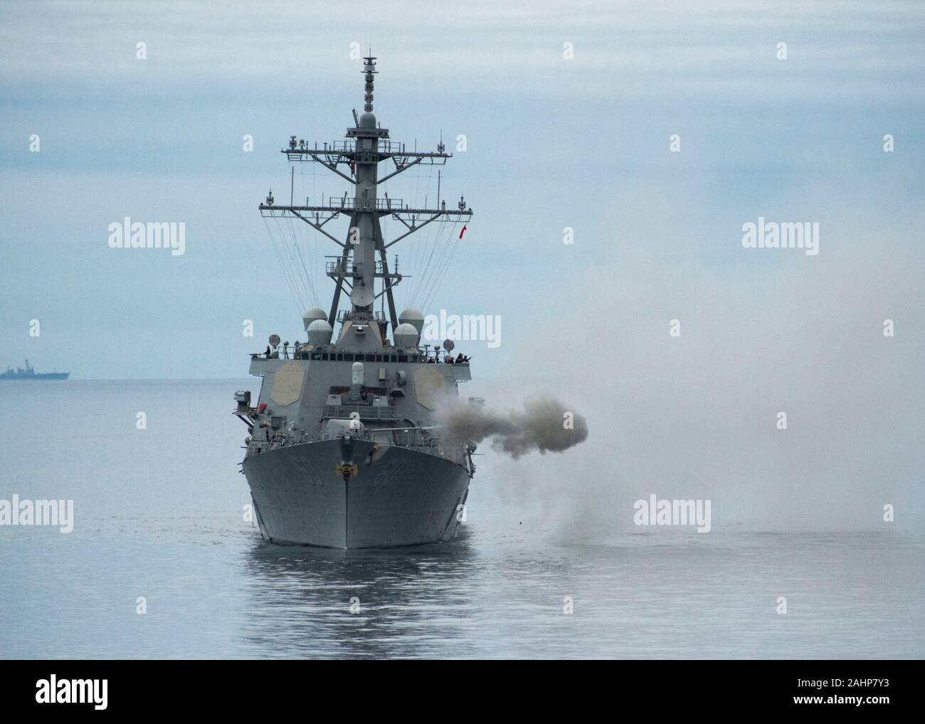 Una marina de clase Arleigh Burke de destructores de misiles guiados USS Paul Hamilton desencadena una marca 45, pistola de 5 pulgadas durante un ejercicio de fuego vivo mientras se llevan a cabo, el 7 de diciembre de 2019 en el Océano Pacífico. Foto de stock