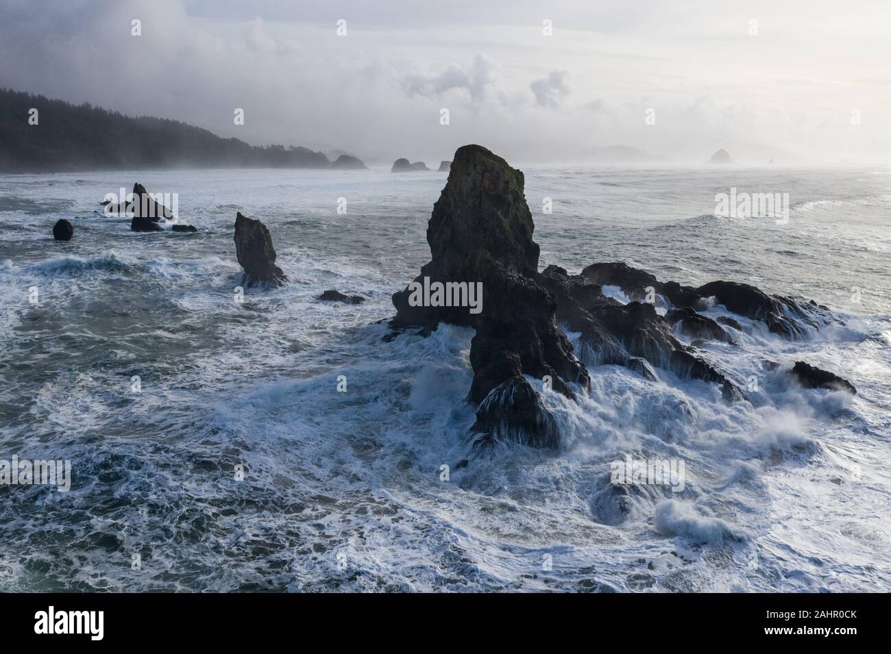El Océano Pacífico se estrelle contra las rocas de la costa del norte de Oregon. Esta región salvaje, justo al oeste de Portland, es a menudo cubierto por nubes oscuras. Foto de stock