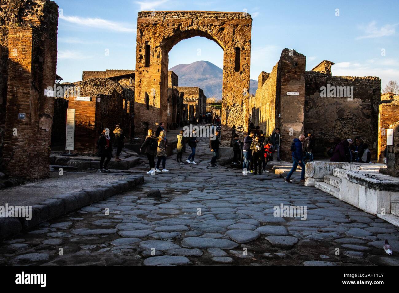 Los turistas delante de una arcada framing Mt Vesuvesius, Pompeya, Italia Foto de stock