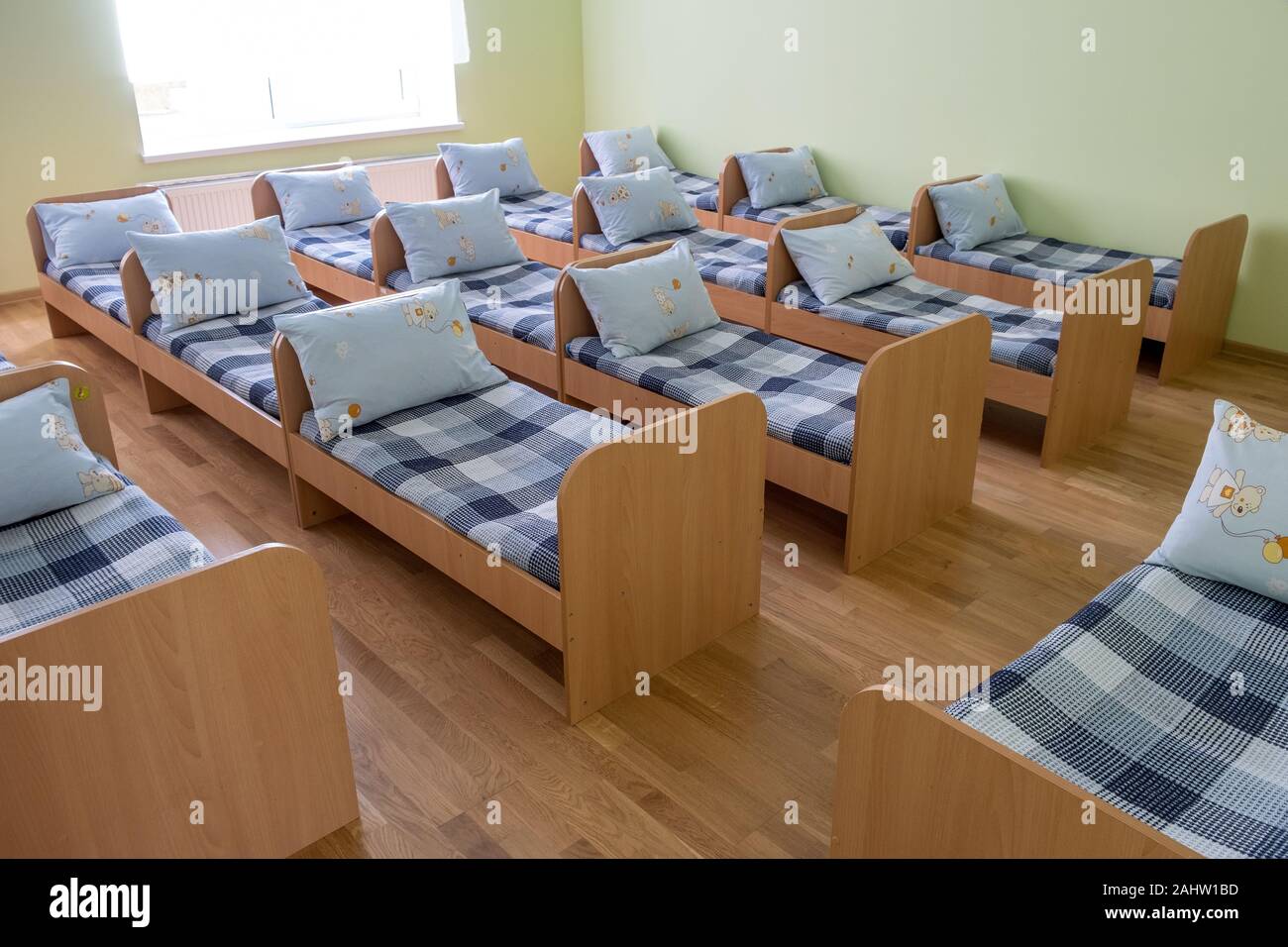 Muchas pequeñas camas con sábanas en guarderías preescolares dormitorio  vacío interior para cómoda siesta de los niños Fotografía de stock - Alamy