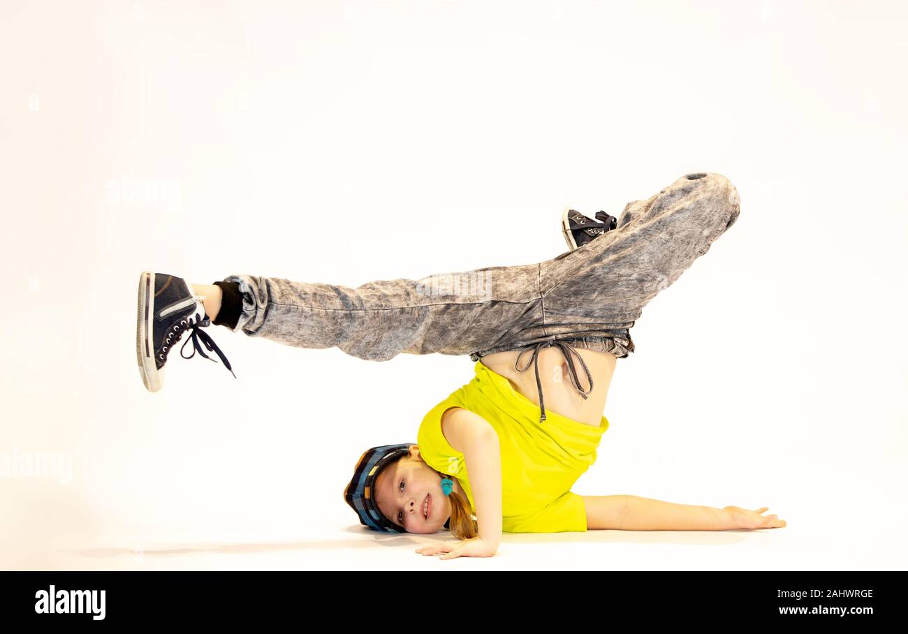 Chica en una singular posición de baile, breakdance kid, una niña