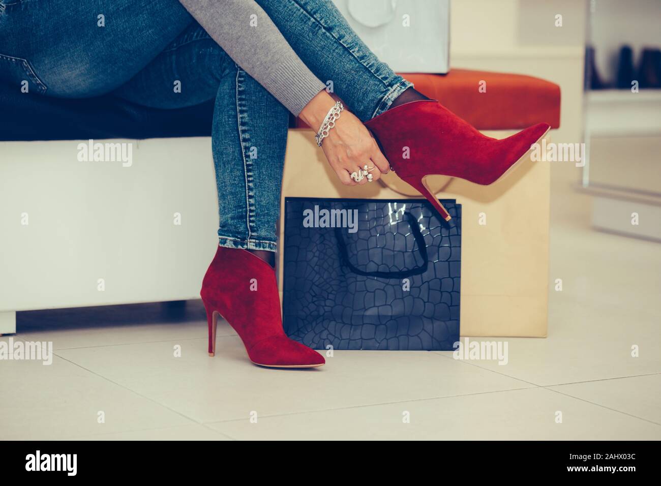 Mujer haciendo unas compras y tratando de nuevo par de tacones altos en una  tienda de moda Fotografía de stock - Alamy